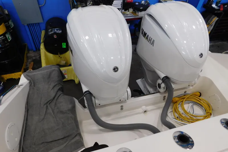 Three Point O.h. Yacht Photos Pics 2022 Pursuit S 328 Sport boat with dual Yamaha outboard engines in a workshop setting.