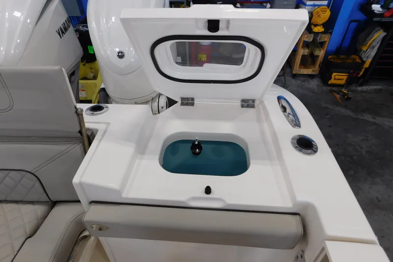 Three Point O.h. Yacht Photos Pics 2022 Pursuit S 328 Sport boat with open livewell and Yamaha engine in garage.