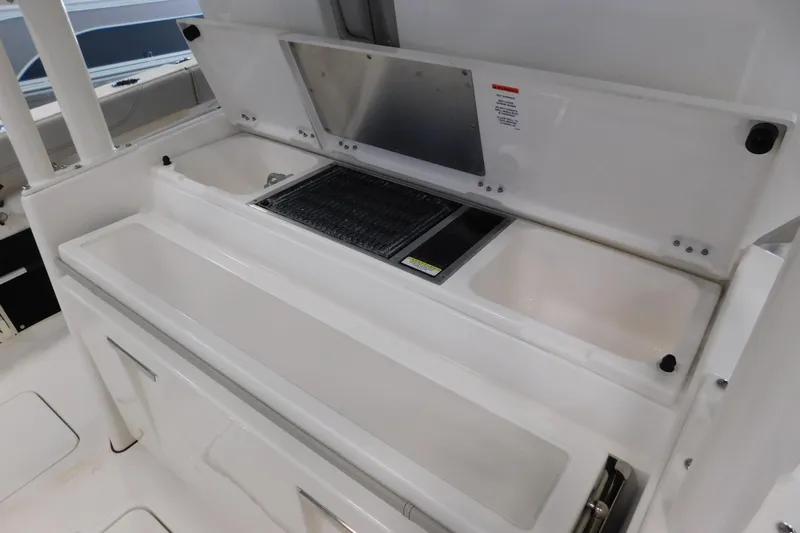 Three Point O.h. Yacht Photos Pics 2022 Pursuit S 328 Sport boat interior with storage compartments and sink.