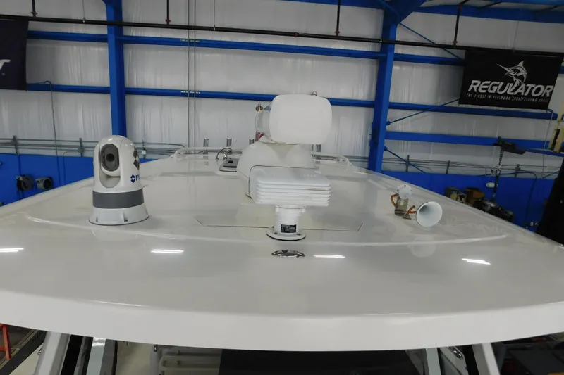 Three Point O.h. Yacht Photos Pics 2022 Pursuit S 328 Sport boat roof with radar and camera equipment in a blue and white warehouse.