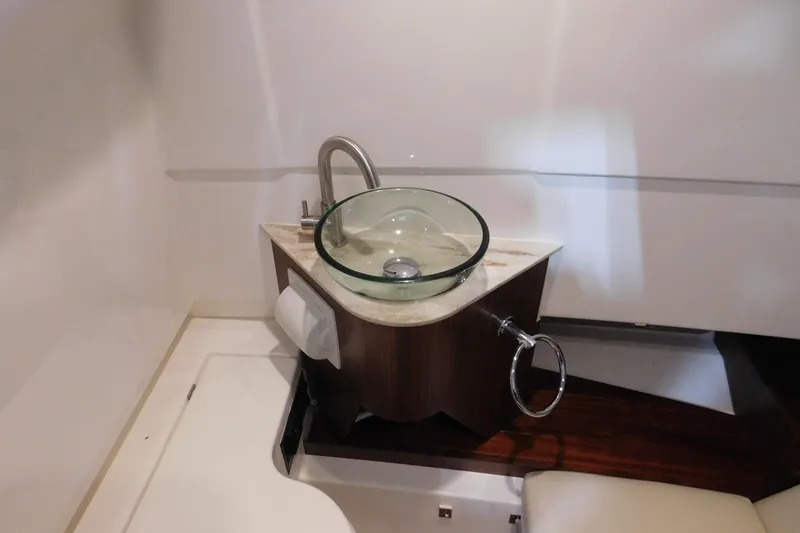 Three Point O.h. Yacht Photos Pics 2022 Pursuit S 328 Sport boat interior with modern glass sink and wooden accents.