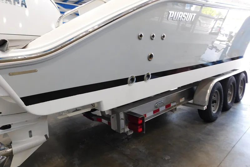 Three Point O.h. Yacht Photos Pics 2022 Pursuit S 328 Sport boat on a trailer in a showroom.