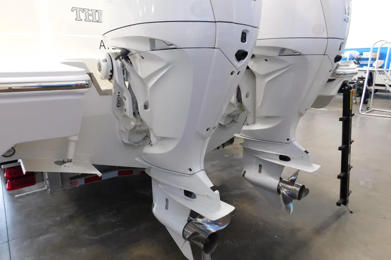 Three Point O.h. Yacht Photos Pics 2022 Pursuit S 328 Sport boat with dual outboard engines in a showroom.