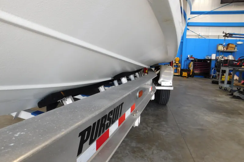 Three Point O.h. Yacht Photos Pics 2022 Pursuit S 328 Sport boat on trailer in a workshop setting.