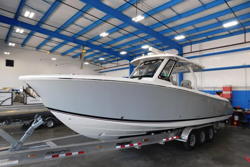 Three Point O.h. Yacht Photos Pics 2022 Pursuit S 328 Sport boat on trailer in indoor storage facility.