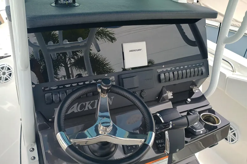  Yacht Photos Pics 2025 Blackfin 272 CC boat dashboard with steering wheel and control panel.