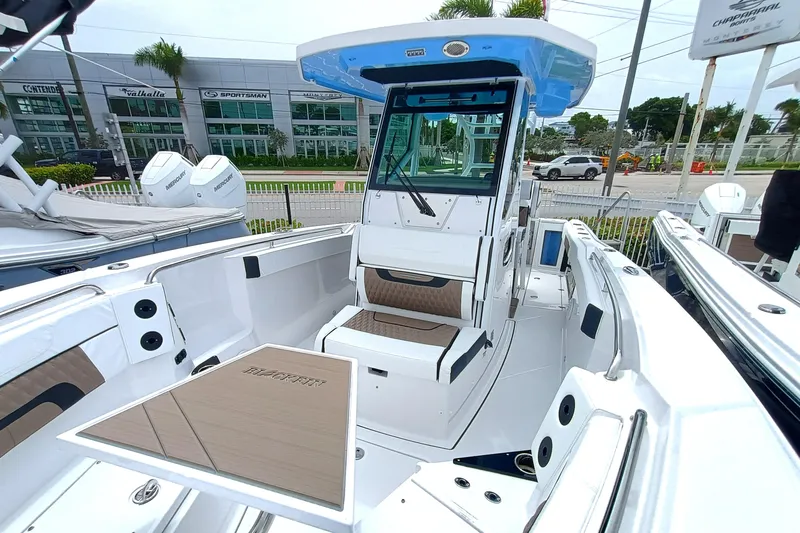  Yacht Photos Pics 2025 Blackfin 272 CC boat interior with modern seating and console, displayed outdoors.