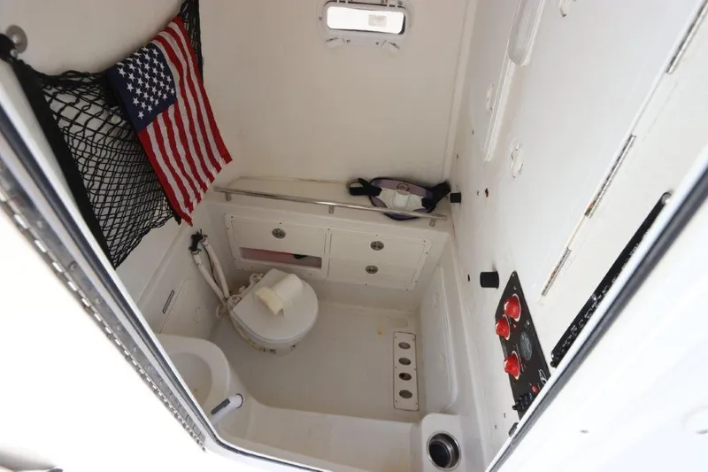  Yacht Photos Pics 2013 Sailfish 320 CC boat interior with toilet, storage, and American flag.
