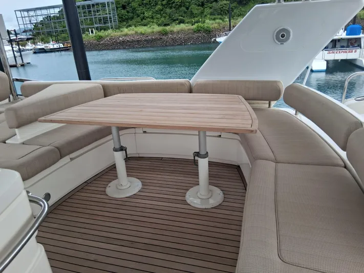  Yacht Photos Pics Luxury seating area on 2008 Fairline Squadron 74 yacht with wooden table and cushioned benches.