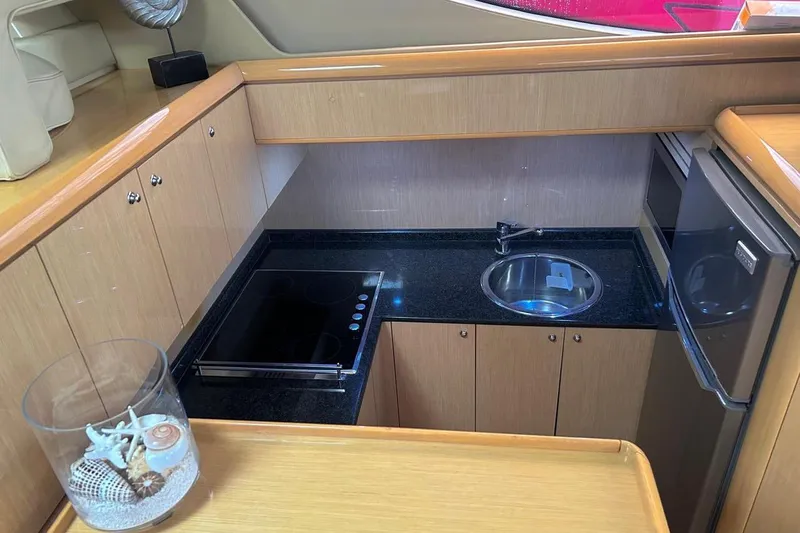  Yacht Photos Pics Compact kitchen in 2008 Fairline Squadron 74 yacht with stove, sink, and fridge.