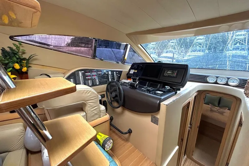  Yacht Photos Pics 2008 Fairline Squadron 74 yacht interior with helm, controls, and wooden stairs.