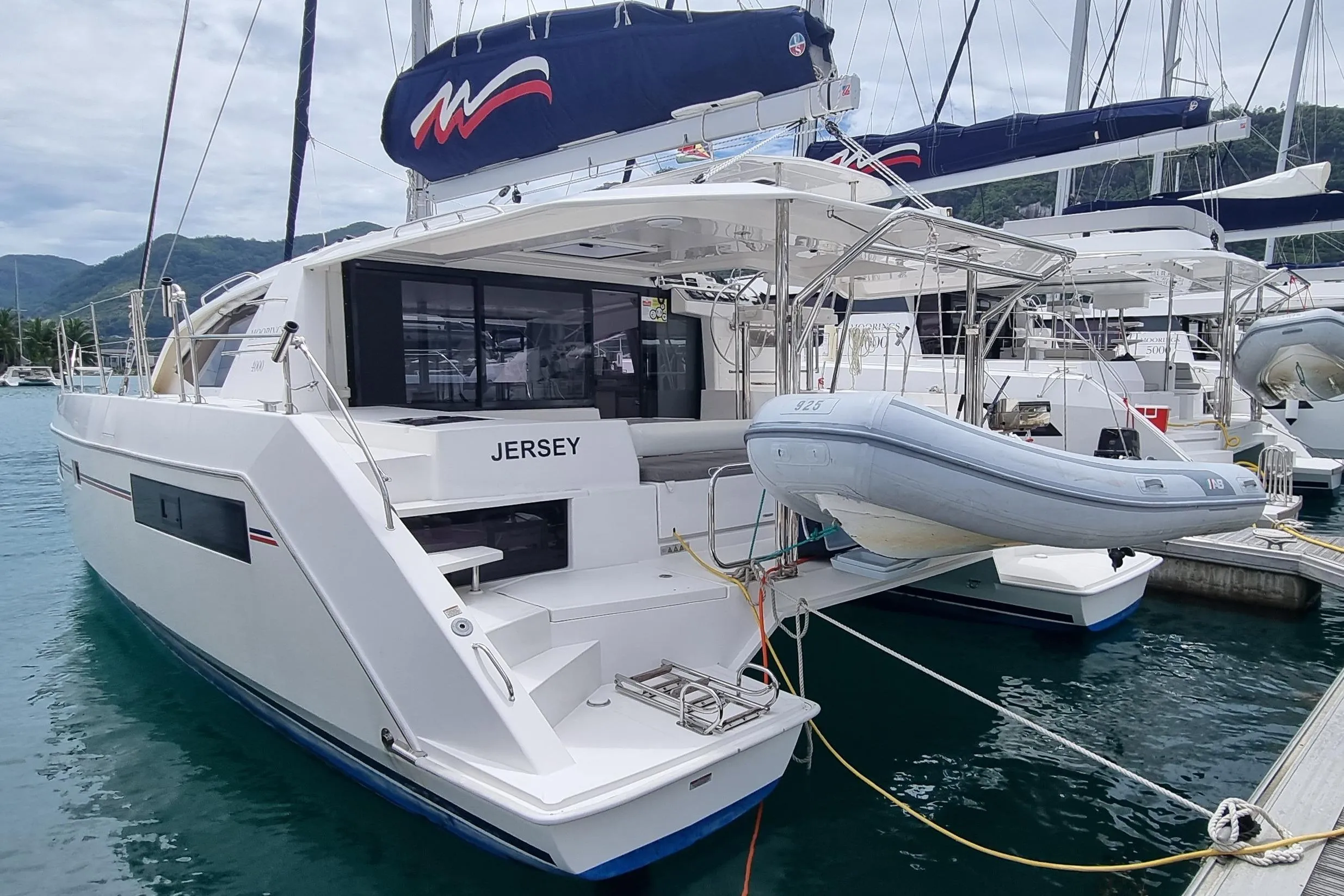 2020 Leopard 40 catamaran docked with inflatable dinghy, scenic marina backdrop.