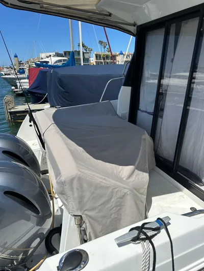 Destination Unknown II Yacht Photos Pics 2021 Jeanneau NC 895 boat docked, covered seating area, dual outboard motors.