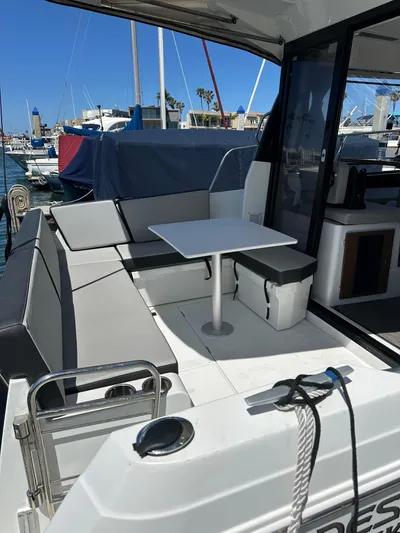 Destination Unknown II Yacht Photos Pics 2021 Jeanneau NC 895 boat with outdoor seating and table, docked at marina.