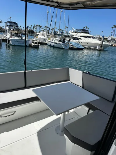 Destination Unknown II Yacht Photos Pics 2021 Jeanneau NC 895 boat with seating area, docked in a marina with yachts.