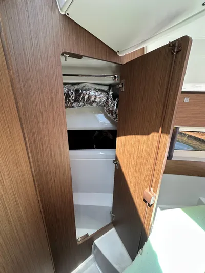 Destination Unknown II Yacht Photos Pics 2021 Jeanneau NC 895 interior with open wooden cabinet door.