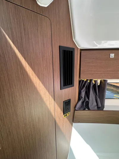 Destination Unknown II Yacht Photos Pics Interior of 2021 Jeanneau NC 895 boat with wood paneling and window curtain.