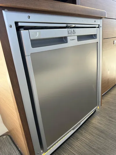 Destination Unknown II Yacht Photos Pics Compact refrigerator inside 2021 Jeanneau NC 895 boat, featuring sleek stainless steel design.