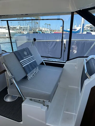 Destination Unknown II Yacht Photos Pics 2021 Jeanneau NC 895 interior with gray seating and marina view.