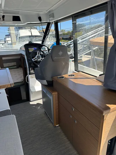 Destination Unknown II Yacht Photos Pics Interior of 2021 Jeanneau NC 895 boat, featuring helm, seating, and cabinetry.
