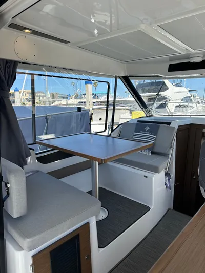 Destination Unknown II Yacht Photos Pics Interior of 2021 Jeanneau NC 895 boat with seating and table, docked at marina.