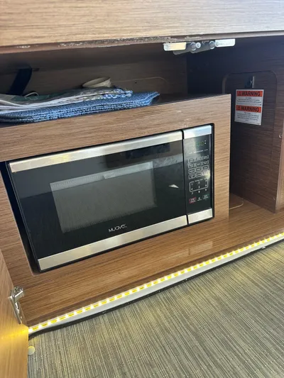 Destination Unknown II Yacht Photos Pics Microwave in 2021 Jeanneau NC 895 boat interior, wooden cabinetry, modern design.