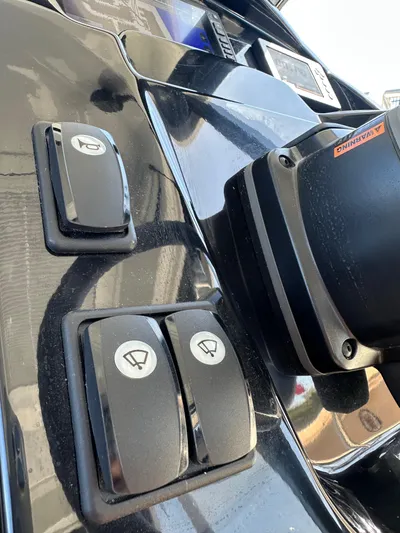 Destination Unknown II Yacht Photos Pics Control panel of a 2021 Jeanneau NC 895 boat with switches and steering components.