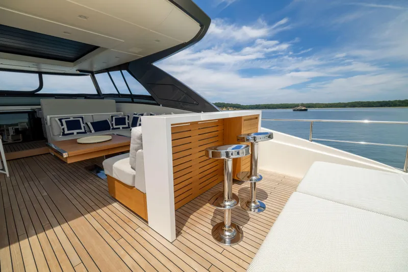 Sori San Lorenzo Yacht Photos Pics Luxurious 2024 Sanlorenzo SL90A yacht deck with seating and bar stools, overlooking serene waters.