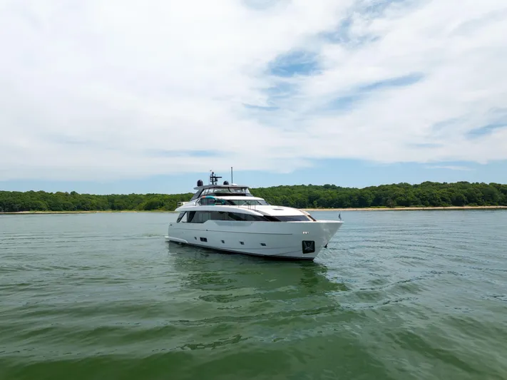 Sori San Lorenzo Yacht Photos Pics 2024 Sanlorenzo SL90A yacht cruising on calm waters near a lush shoreline.