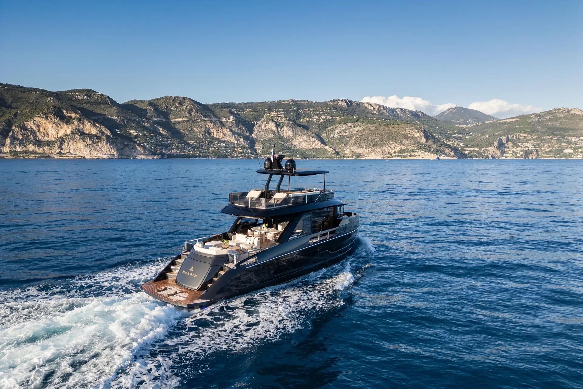 Luxurious 2025 Explorer 62 yacht cruising near scenic coastal cliffs.