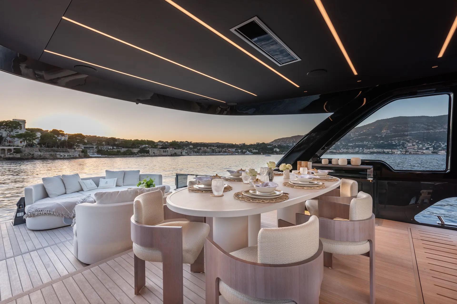 Luxurious Explorer 62 yacht deck with elegant dining setup, overlooking serene waters at sunset, 2025 model.