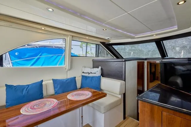  Yacht Photos Pics Interior of 2015 Carver C34 Command Bridge with dining area and blue cushions.