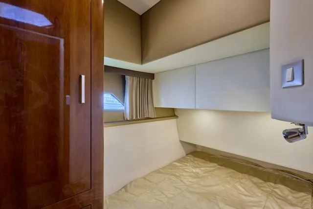  Yacht Photos Pics Interior cabin of 2015 Carver C34 Command Bridge yacht, featuring a cozy bed and wooden cabinetry.