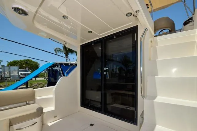  Yacht Photos Pics 2015 Carver C34 Command Bridge yacht with sliding glass doors and staircase, exterior view.