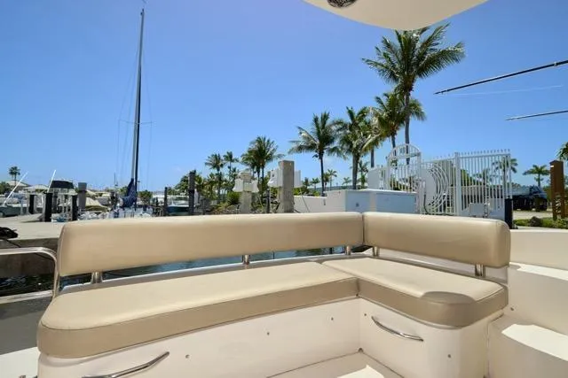  Yacht Photos Pics 2015 Carver C34 Command Bridge with beige seating, docked near palm trees and clear blue sky.