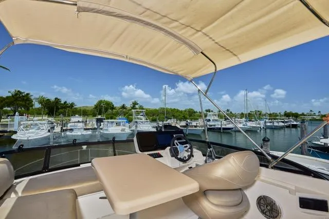  Yacht Photos Pics 2015 Carver C34 Command Bridge yacht interior with marina view, featuring helm and seating area.