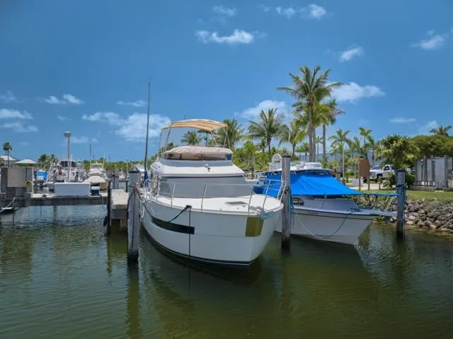  Yacht Photos Pics 2015 Carver C34 Command Bridge yacht docked in a sunny marina with palm trees.