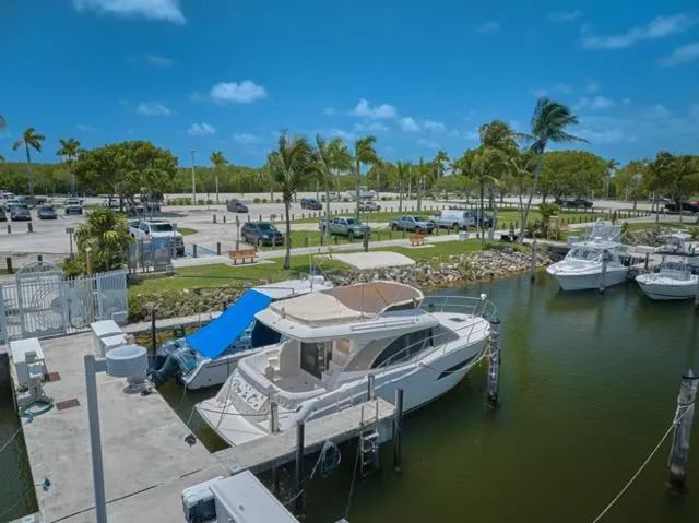 Yacht Photos Pics 2015 Carver C34 Command Bridge yacht docked in a sunny marina with palm trees.