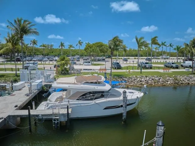  Yacht Photos Pics 2015 Carver C34 Command Bridge yacht docked in a sunny marina with palm trees.