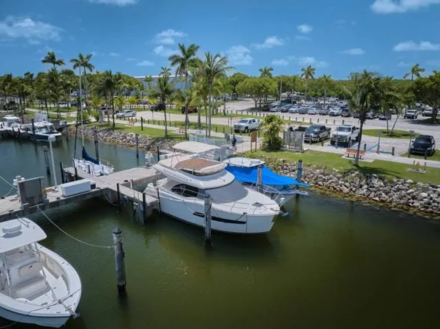  Yacht Photos Pics 2015 Carver C34 Command Bridge yacht docked at a marina with palm trees and parked cars.