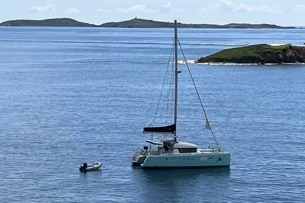 Zun Zun Yacht Photos Pics 2014 Lagoon 39 catamaran anchored in serene blue waters with distant islands.