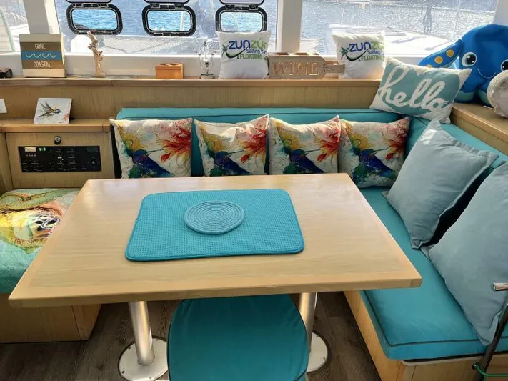 Zun Zun Yacht Photos Pics Cozy interior of 2014 Lagoon 39 catamaran with colorful cushions and turquoise accents.