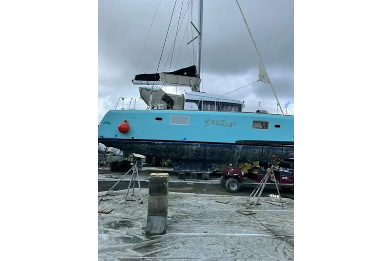 Zun Zun Yacht Photos Pics 2014 Lagoon 39 catamaran on dry dock, blue hull, overcast sky.