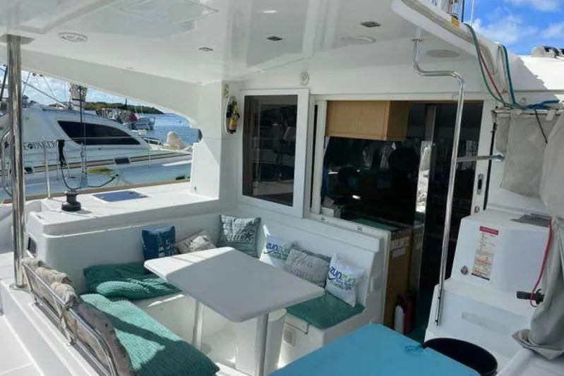 Zun Zun Yacht Photos Pics Cozy outdoor seating area on a 2014 Lagoon 39 catamaran, featuring cushions and a table.
