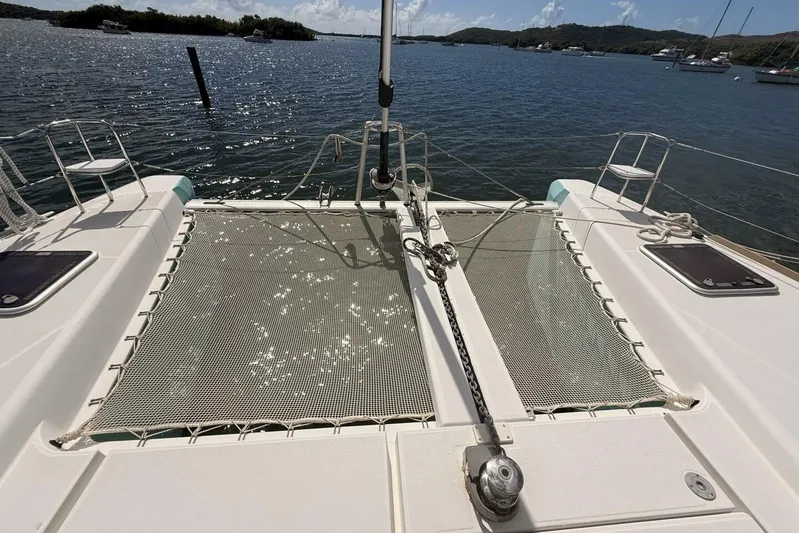 Zun Zun Yacht Photos Pics 2014 Lagoon 39 catamaran deck with netting, anchored in a scenic bay.