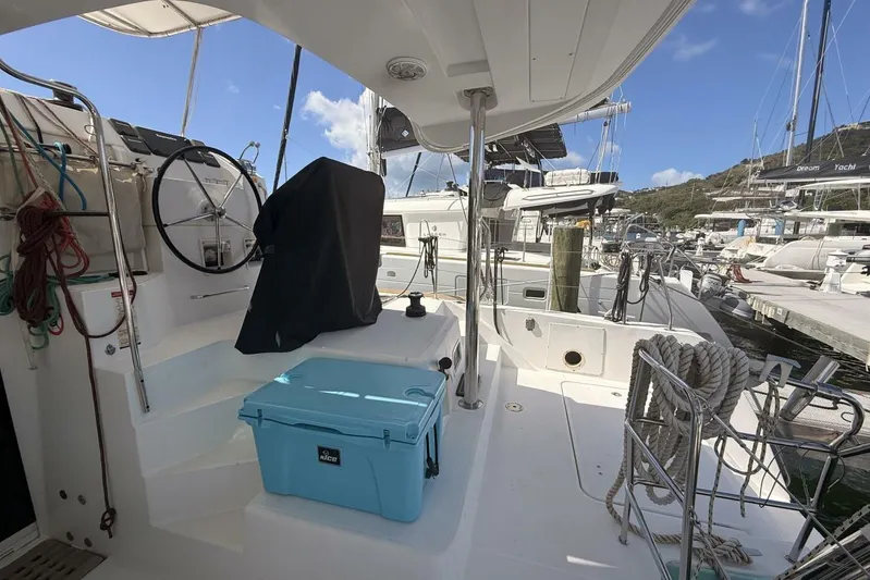 Zun Zun Yacht Photos Pics 2014 Lagoon 39 catamaran cockpit with steering wheel, ropes, and blue cooler at marina.