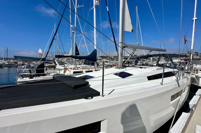 Best Day Ever Yacht Photos Pics 2022 Jeanneau Sun Odyssey 410 sailboat docked in a marina under clear blue skies.