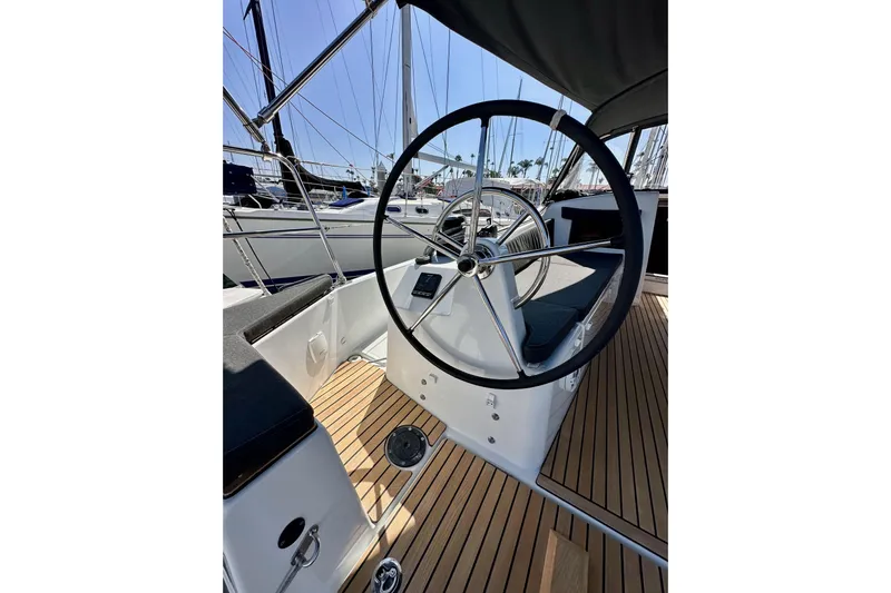 Best Day Ever Yacht Photos Pics Steering wheel of 2022 Jeanneau Sun Odyssey 410 sailboat with teak deck.