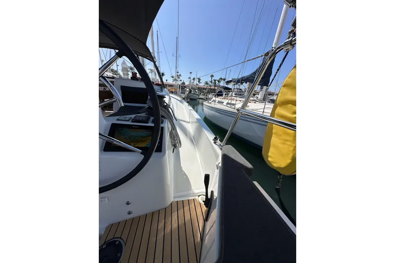 Best Day Ever Yacht Photos Pics 2022 Jeanneau Sun Odyssey 410 sailboat deck with steering wheel and navigation equipment.