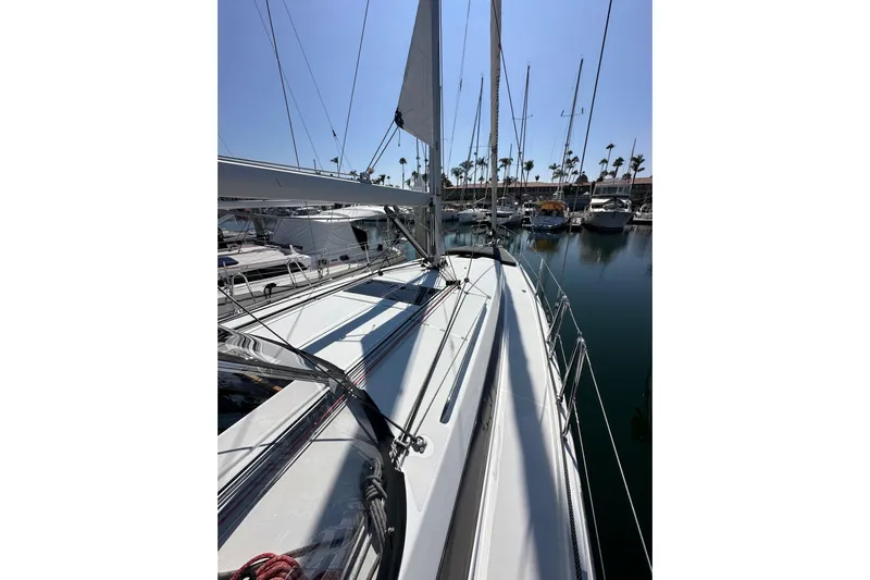 Best Day Ever Yacht Photos Pics 2022 Jeanneau Sun Odyssey 410 sailboat docked in a marina, surrounded by other boats.